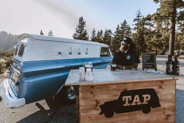 Big Bear custom mobile bar with rustic wooden bartop and baby blue vintage panel truck.